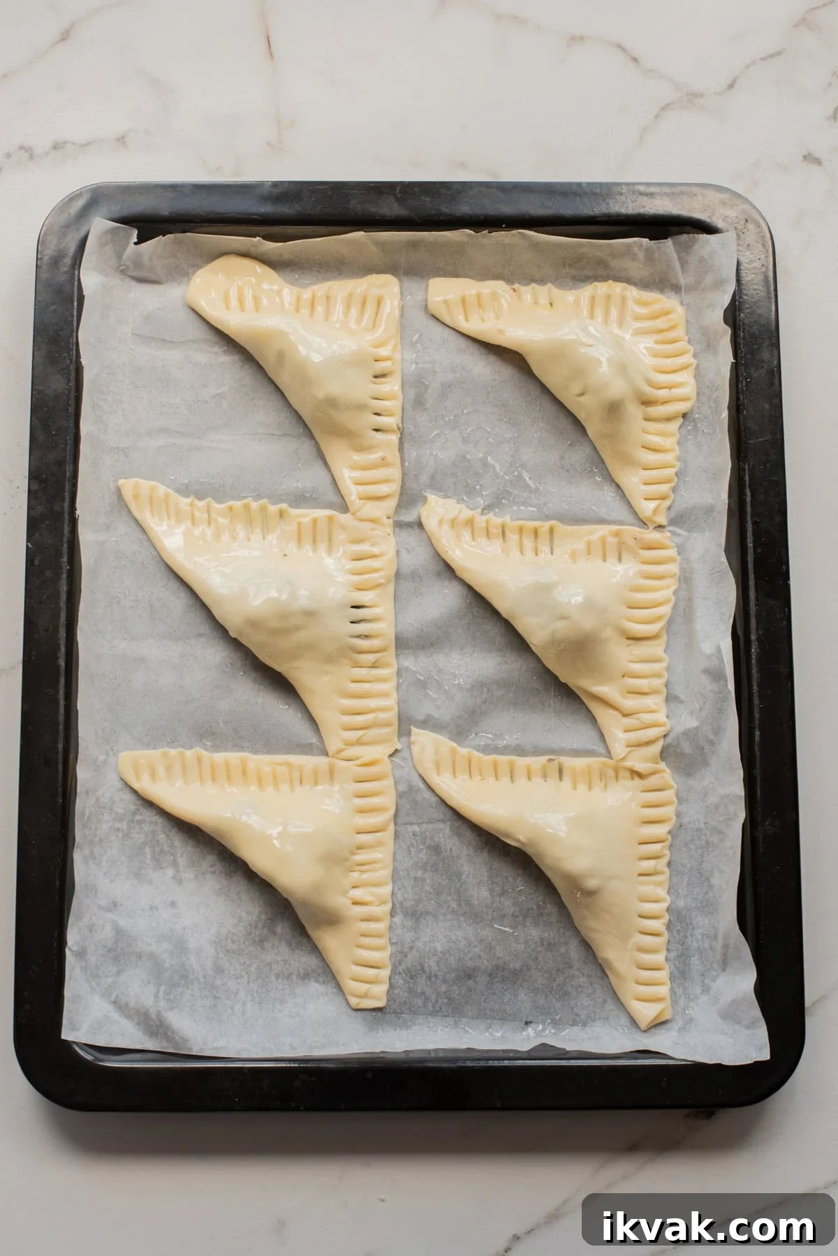 Unbaked Jamaican jerk black-bean patties arranged on a parchment-lined baking tray.