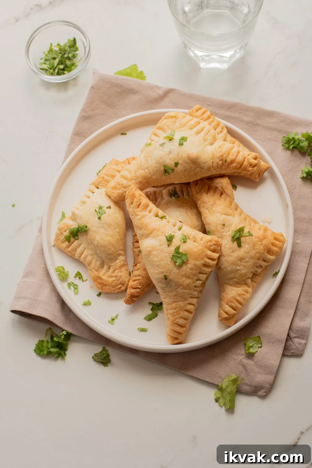 Overhead view of Jamaican jerk black-bean patties on a plate with herbs scattered around.