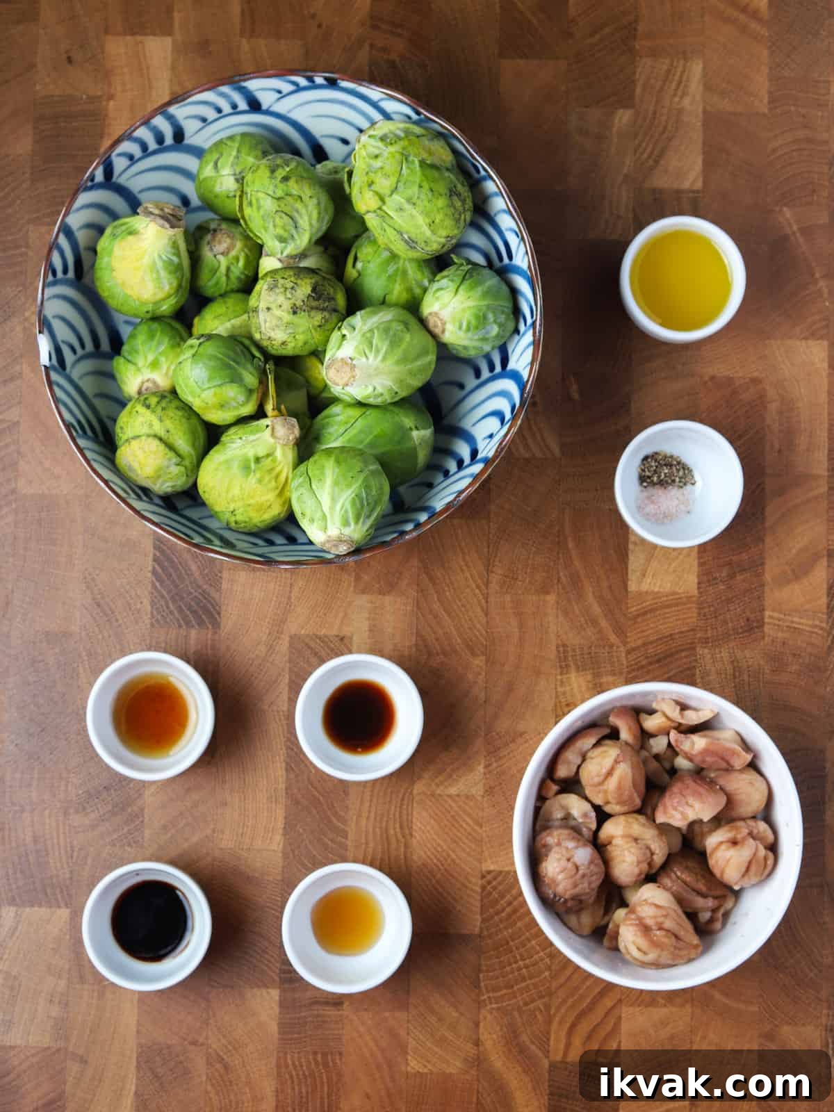 Photo of the ingredients for this vegan roast sprout and chestnut dish, all laid out in bowls on a wooden work surface.