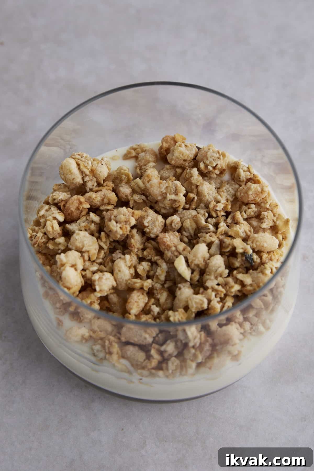 Granola layered on top of yogurt in a glass jar. 