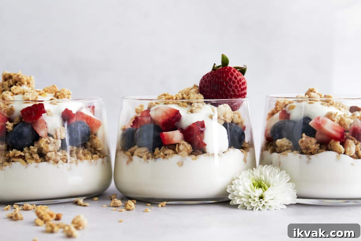 Three jars full of fruit and yogurt parfaits. 