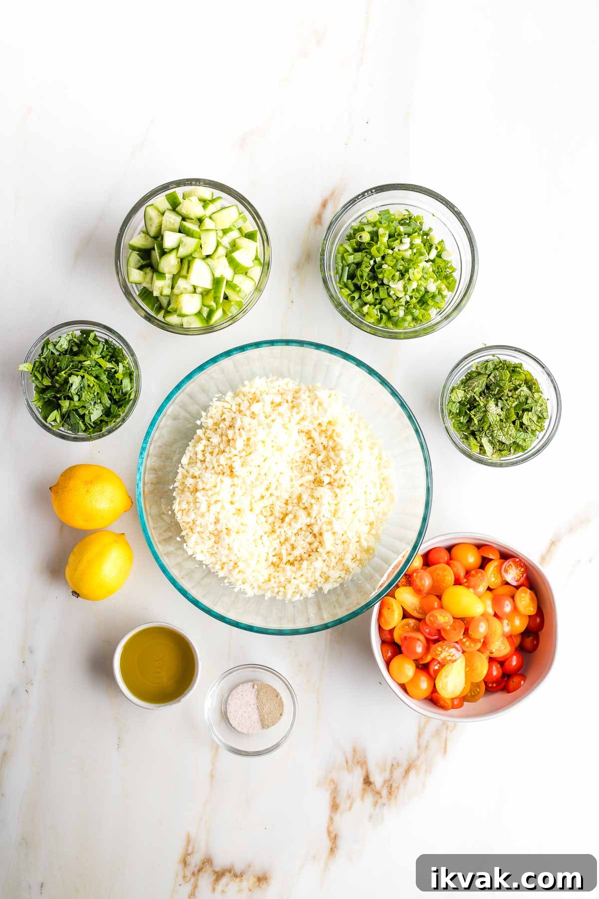Gluten-Free Tabbouleh with Roasted Parsnips 11 Large bowl of riced parsnips, surrounded by small bowls of chopped ingredients plus two lemons and dish of olive oil.