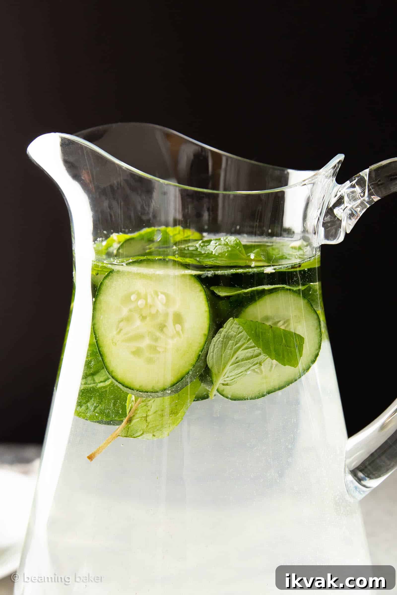 Top of a pitcher of cucumber mint water in front of a black background