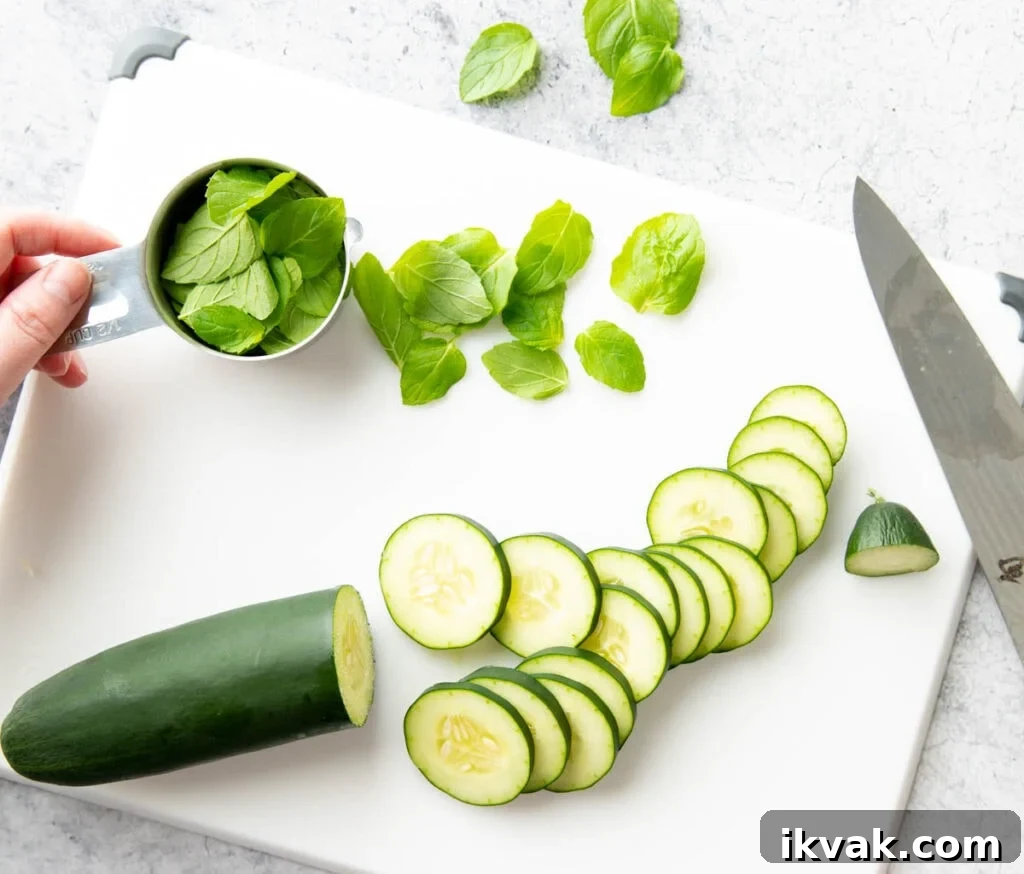 A photo showing How to Make Cucumber Water – slicing cucumbers on a cutting board