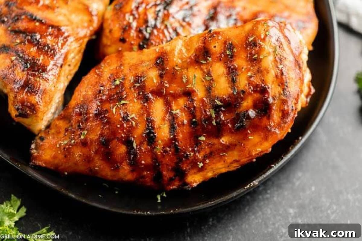 Grilled BBQ Chicken Breast stacked on a plate.