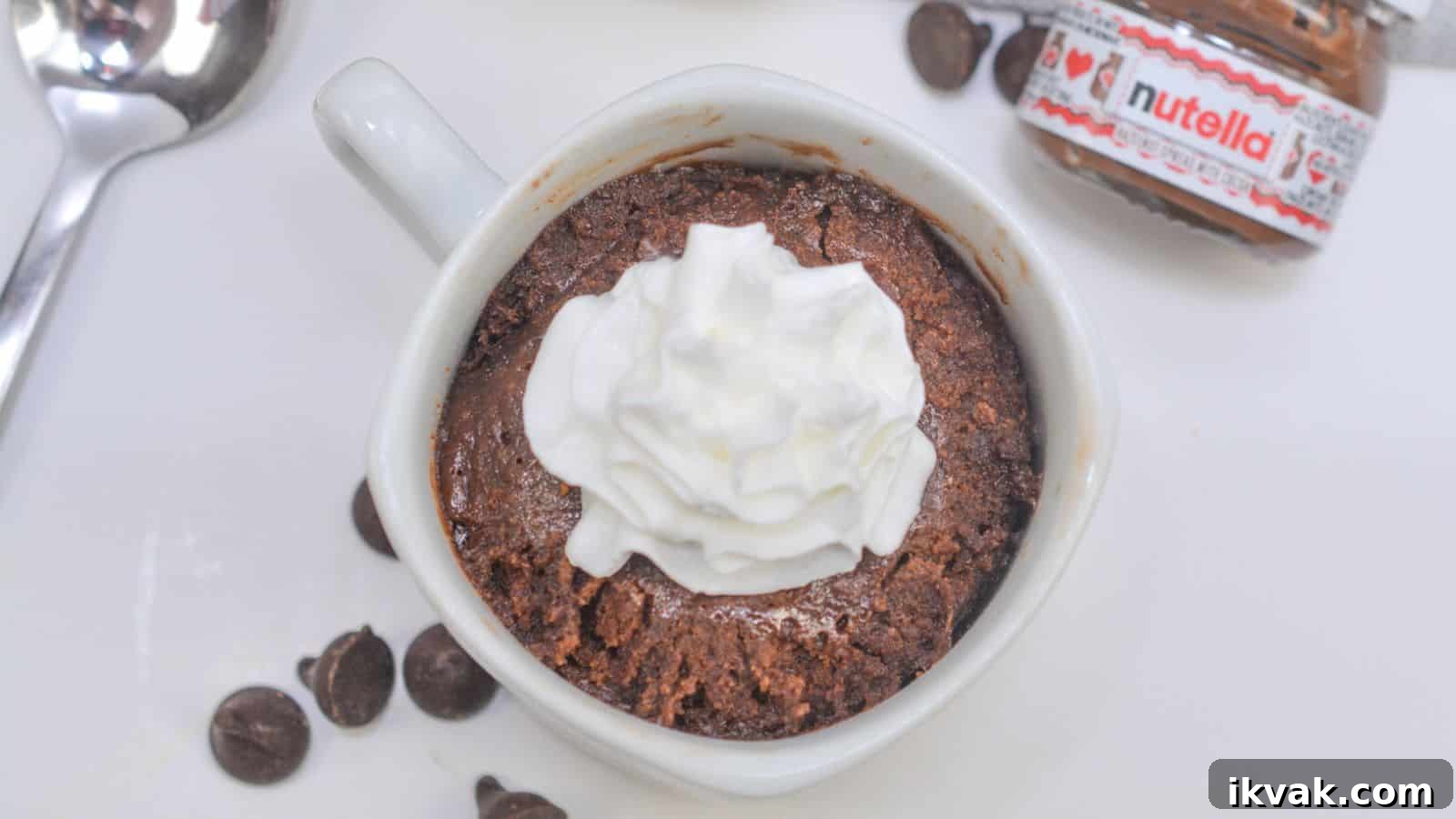 11 Mess-Free Mug Cake Recipes for Quick Single-Serve Desserts 13 Homemade chocolate mug cake topped with whipped cream, served with a spoon and a small nutella jar on the side.