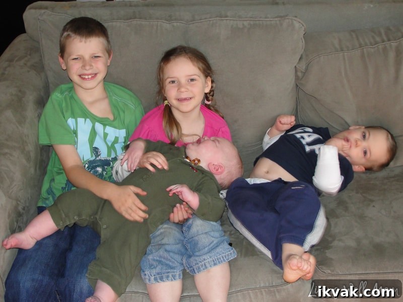 four children sitting on a coach 