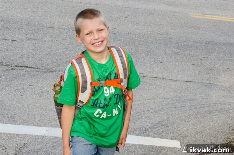 A little boy that is standing in a parking lot