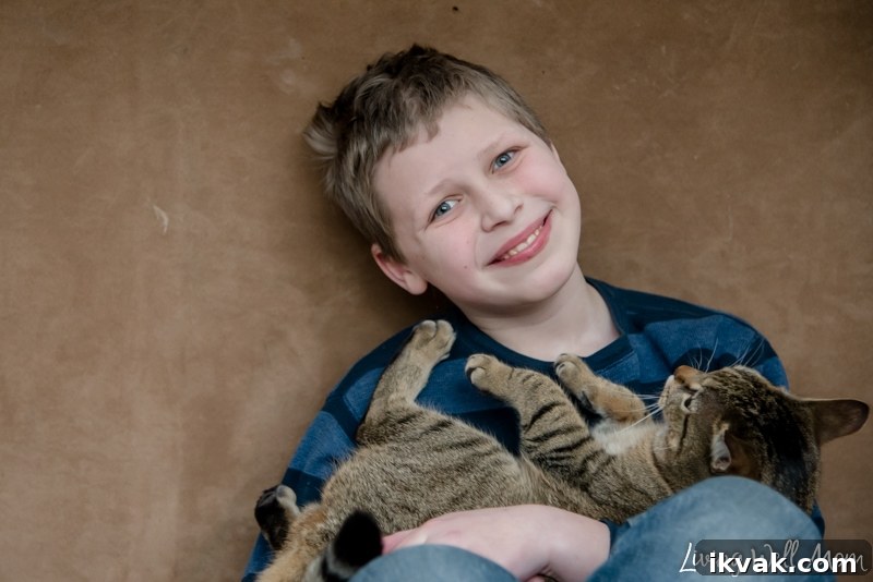 A young boy holding a cat