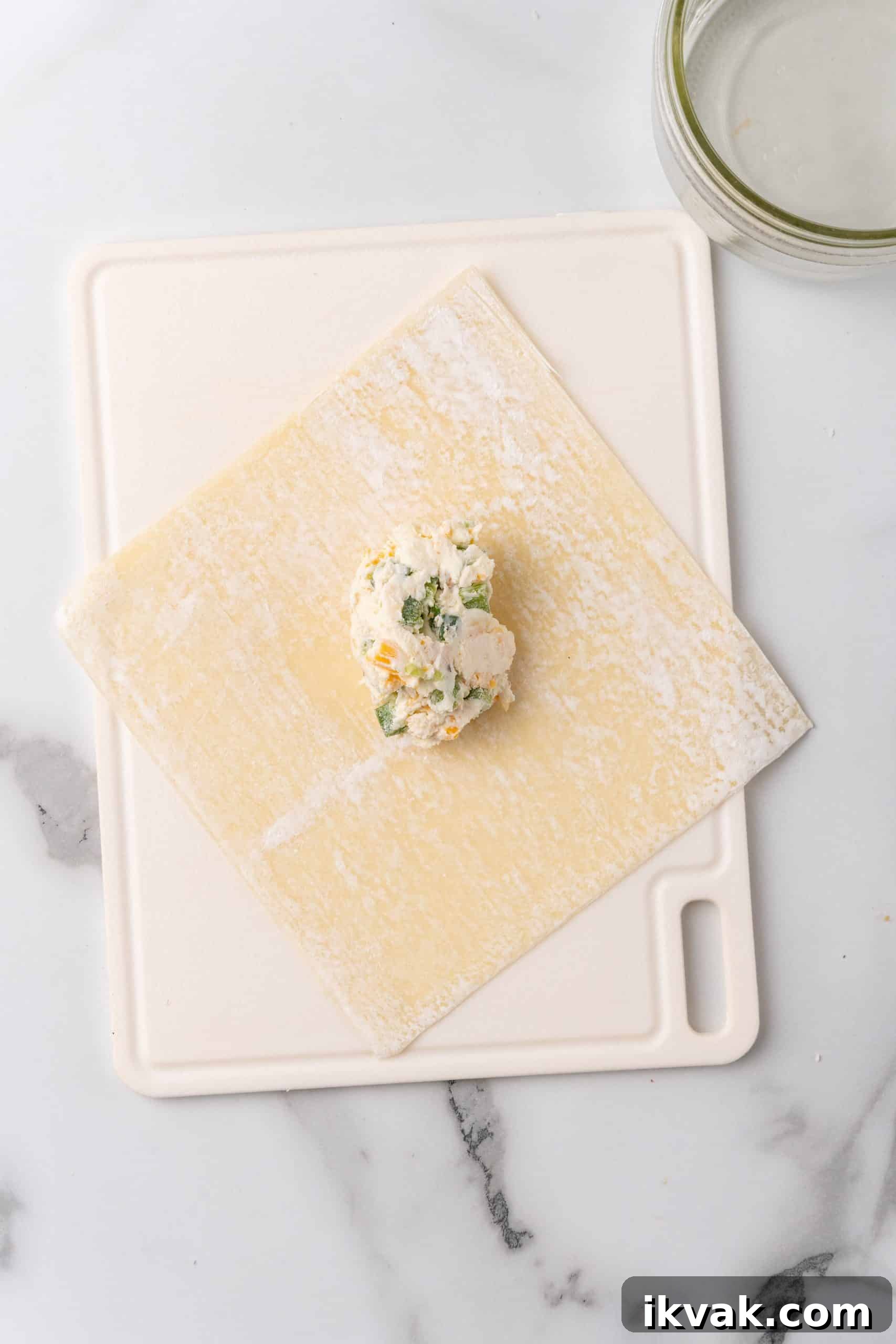 Jalapeño Popper Egg Rolls Recipe — Crispy Stuffed Jalapeño Rolls 6 a spoonful of jalapeno popper cream cheese filling in the center of a wonton wrapper