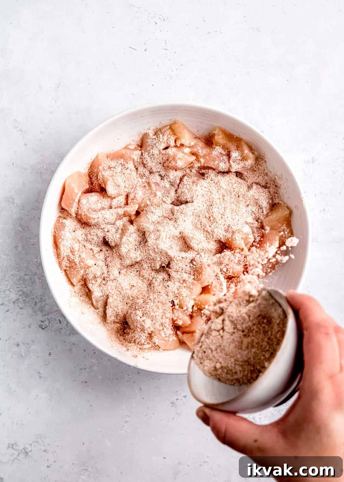 Crispy Air Fryer Buffalo Chicken Bites with Blue Cheese Dip 4 raw chicken being seasoned in white bowl