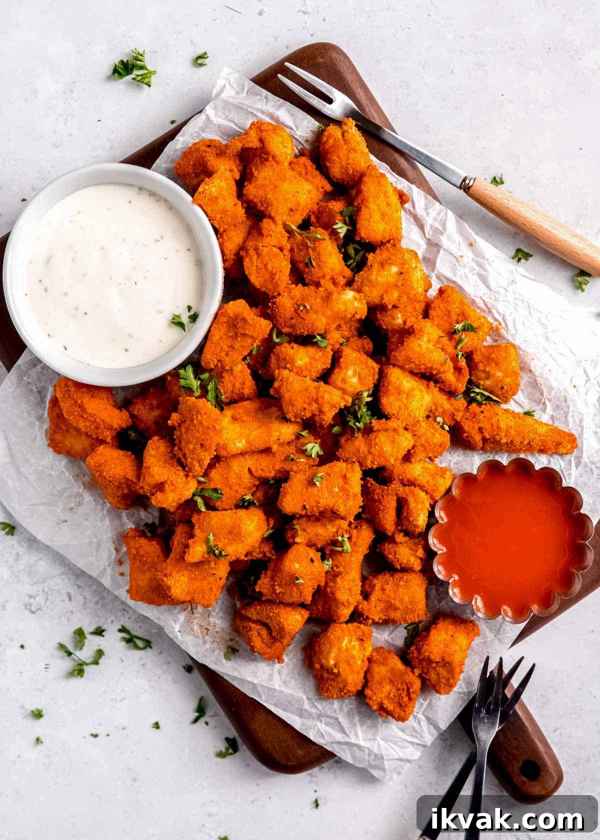 Crispy Air Fryer Buffalo Chicken Bites with Blue Cheese Dip 9 wide view of buffalo chicken bites and dipping sauce on white table