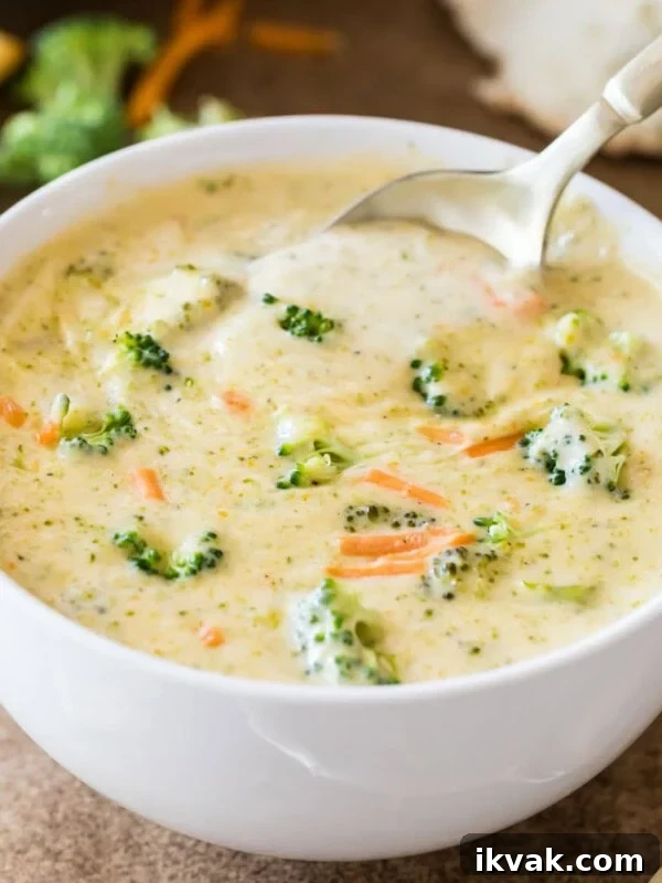 Bowl of broccoli cheddar soup with a spoon scooping out a bite.