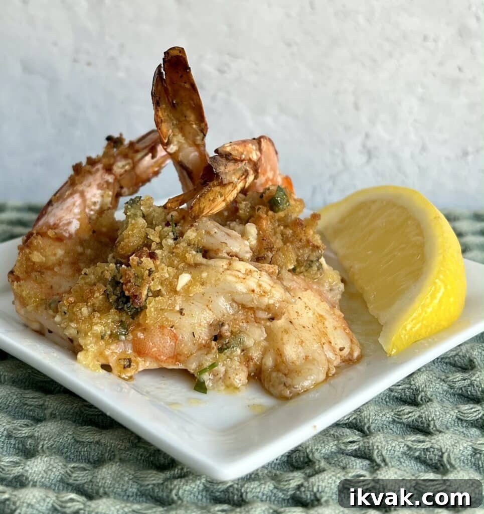 Shrimp Oreganata with White Wine Lemon Butter 3 Close up of 2 pieces of shrimp oreganata with lemon wedge.