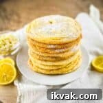 Lemon Drop Cookies Recipe: Soft, Chewy Cookies Like Panera 14 A stack of lemon drop cookies on a white plate, dusted with powdered sugar.