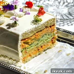 Sliced Sandwichon showing alternating layers of chipotle chicken salad and herb cheese spread between brioche bread on a silver platter.