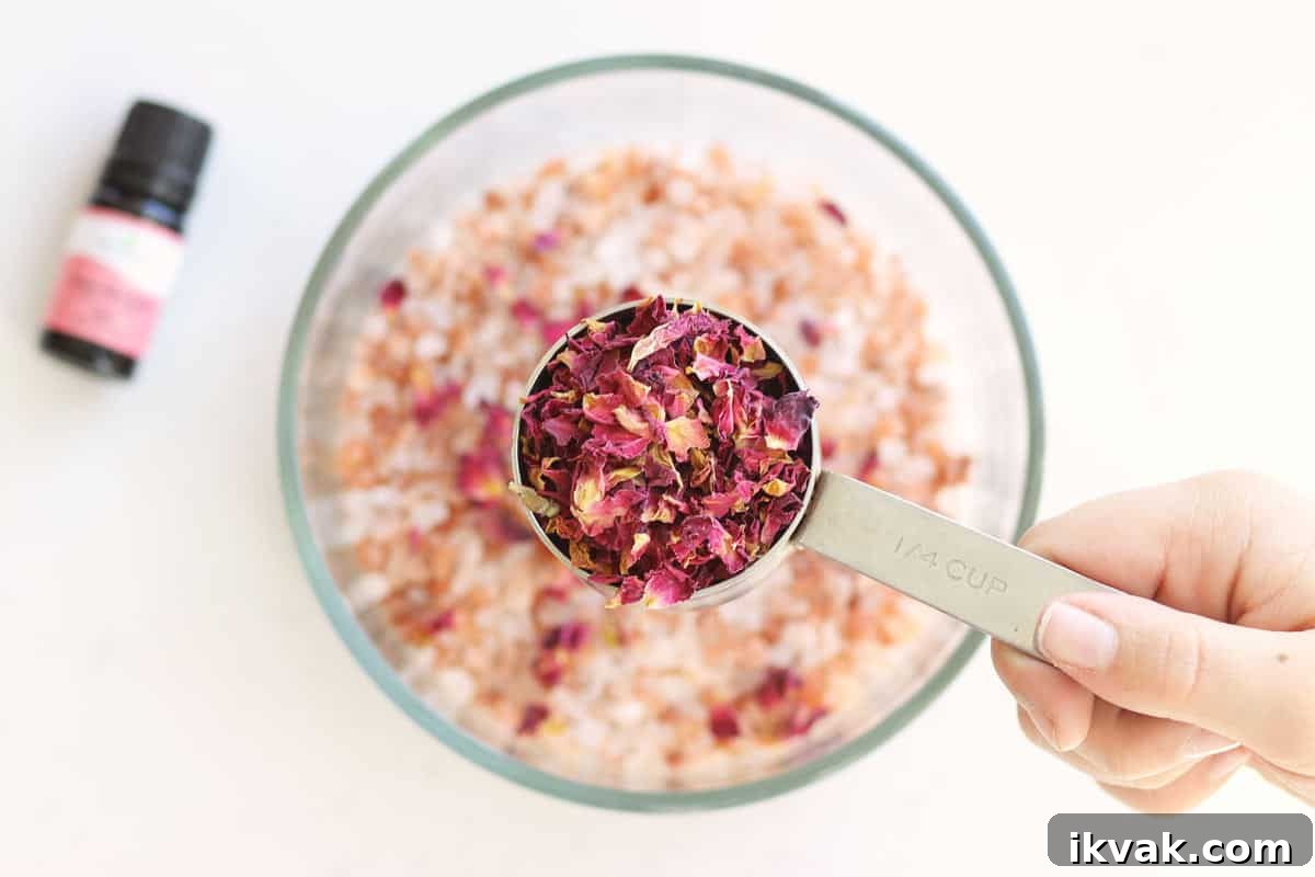 rose petals being added to a bowl of sea salt, Himalayan pink salt to make bath salts.
