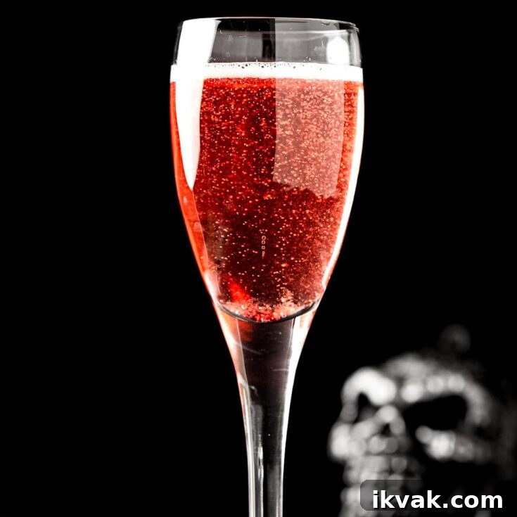 A red halloween mimosa on a black background, with a skull in the background.