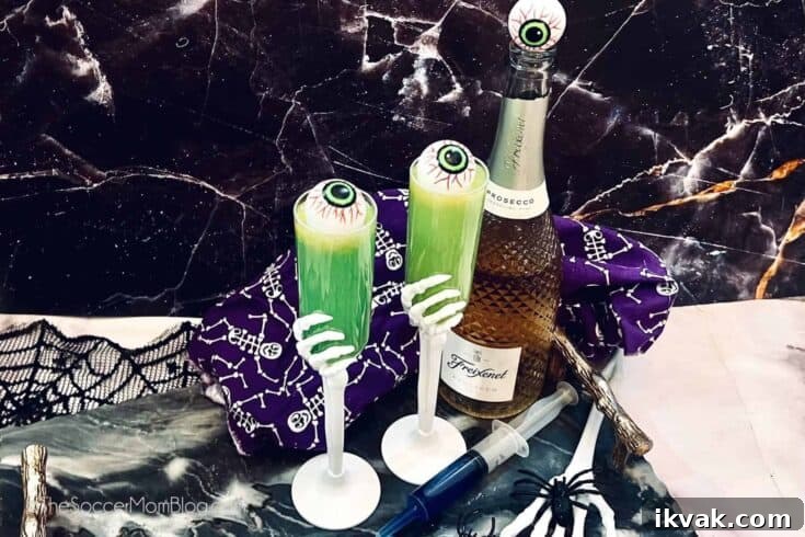 A couple of green Halloween mimosas garnished with eyeballs.