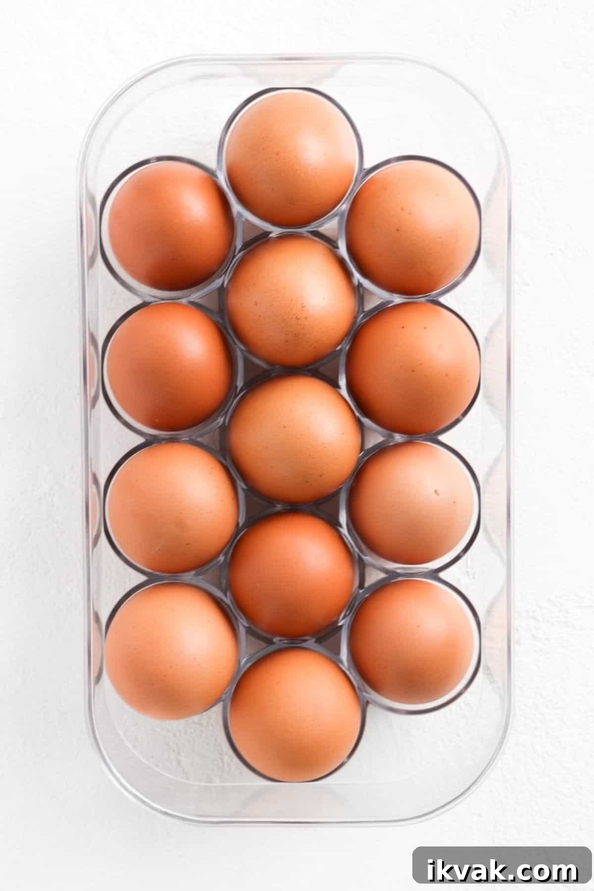 Fourteen brown eggs in a plastic egg holder.
