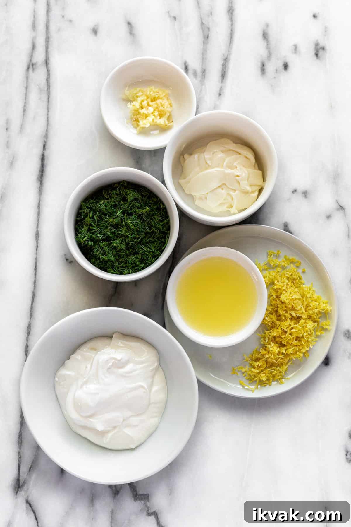 Creamy Dill Sauce for Salmon in 5 Minutes 3 White marble countertop with bowls of ingredients to make creamy dill sauce for salmon.