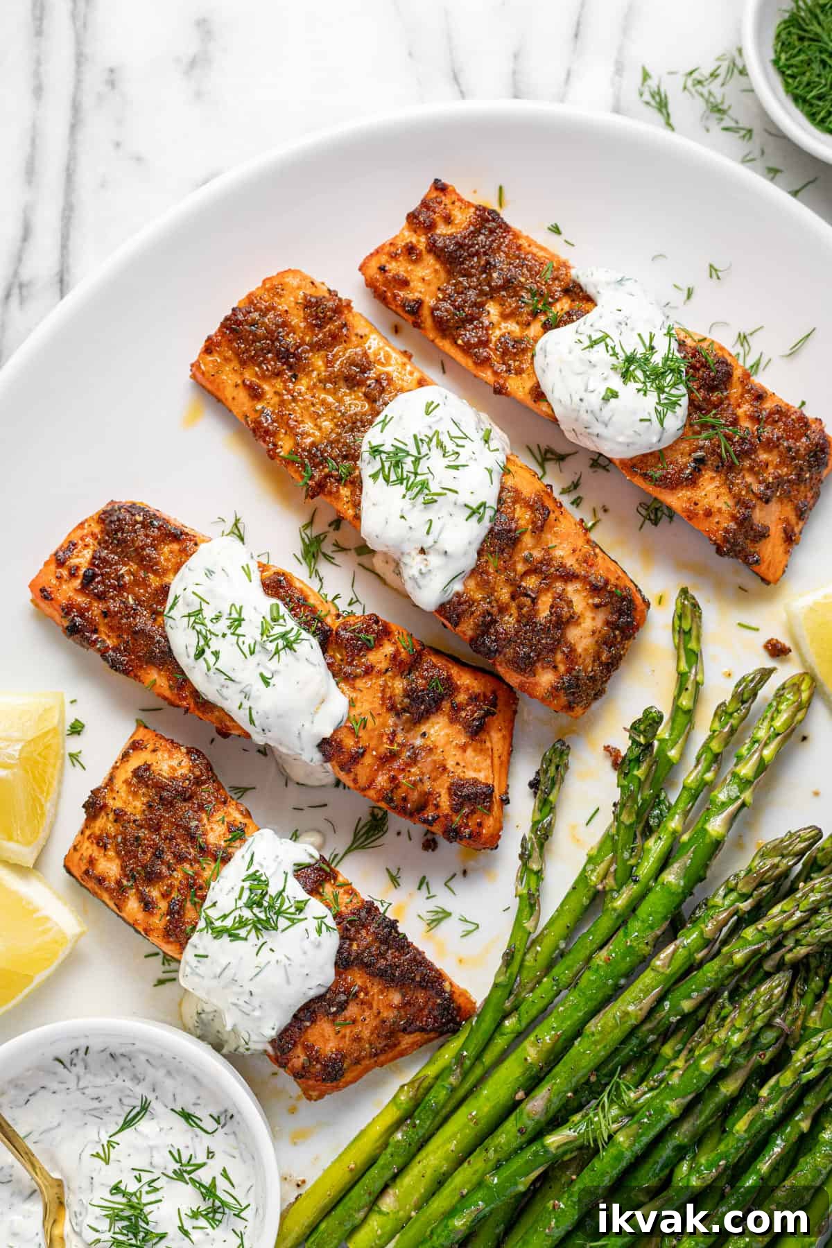 Creamy Dill Sauce for Salmon in 5 Minutes 5 Large white platter filled with salmon, asparagus, and creamy dill sauce.