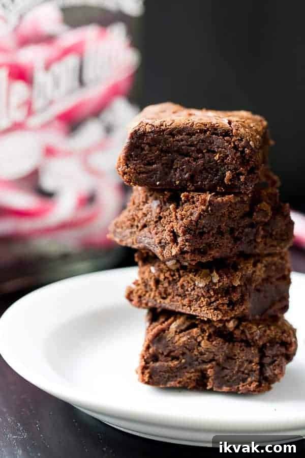 Candy Cane Fudge Brownies pieces stack on each other on a plate 