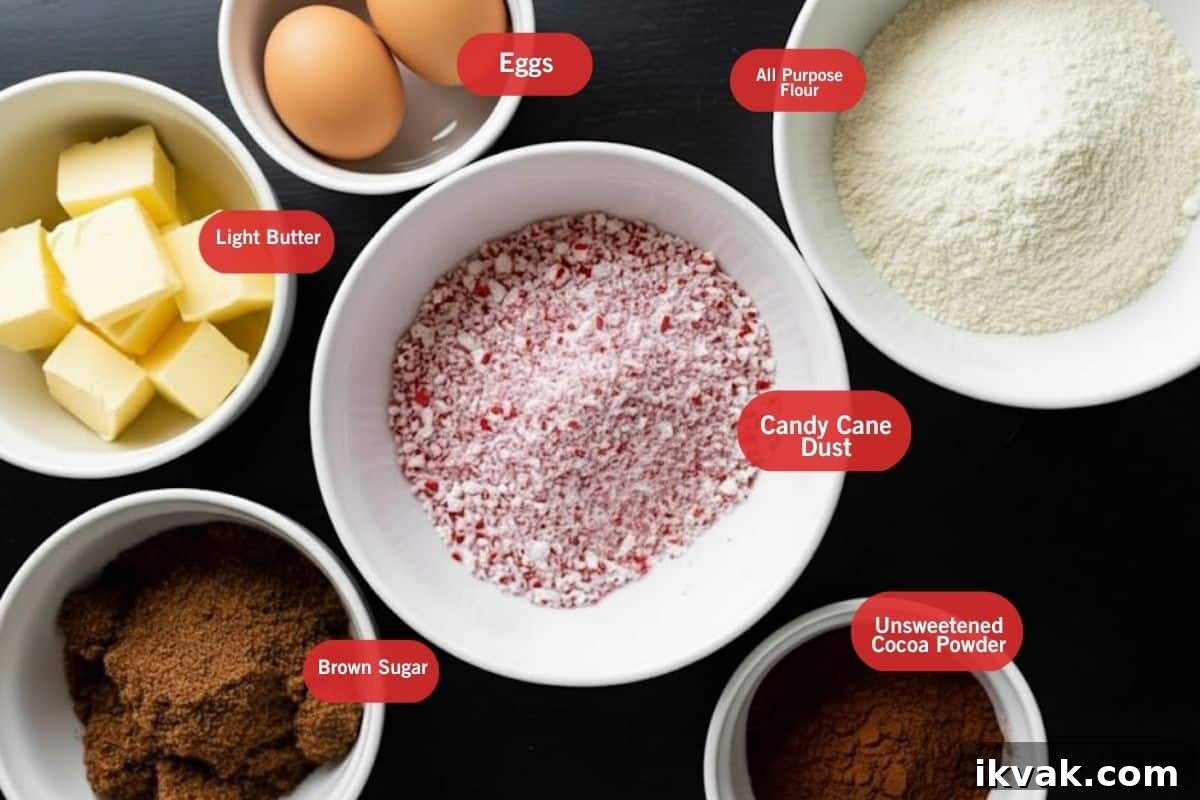 Flat lay photo of ingredient shot of light butter, eggs, all purpose flour, candy cane dust, brown sugar and unsweetened cocoa powder