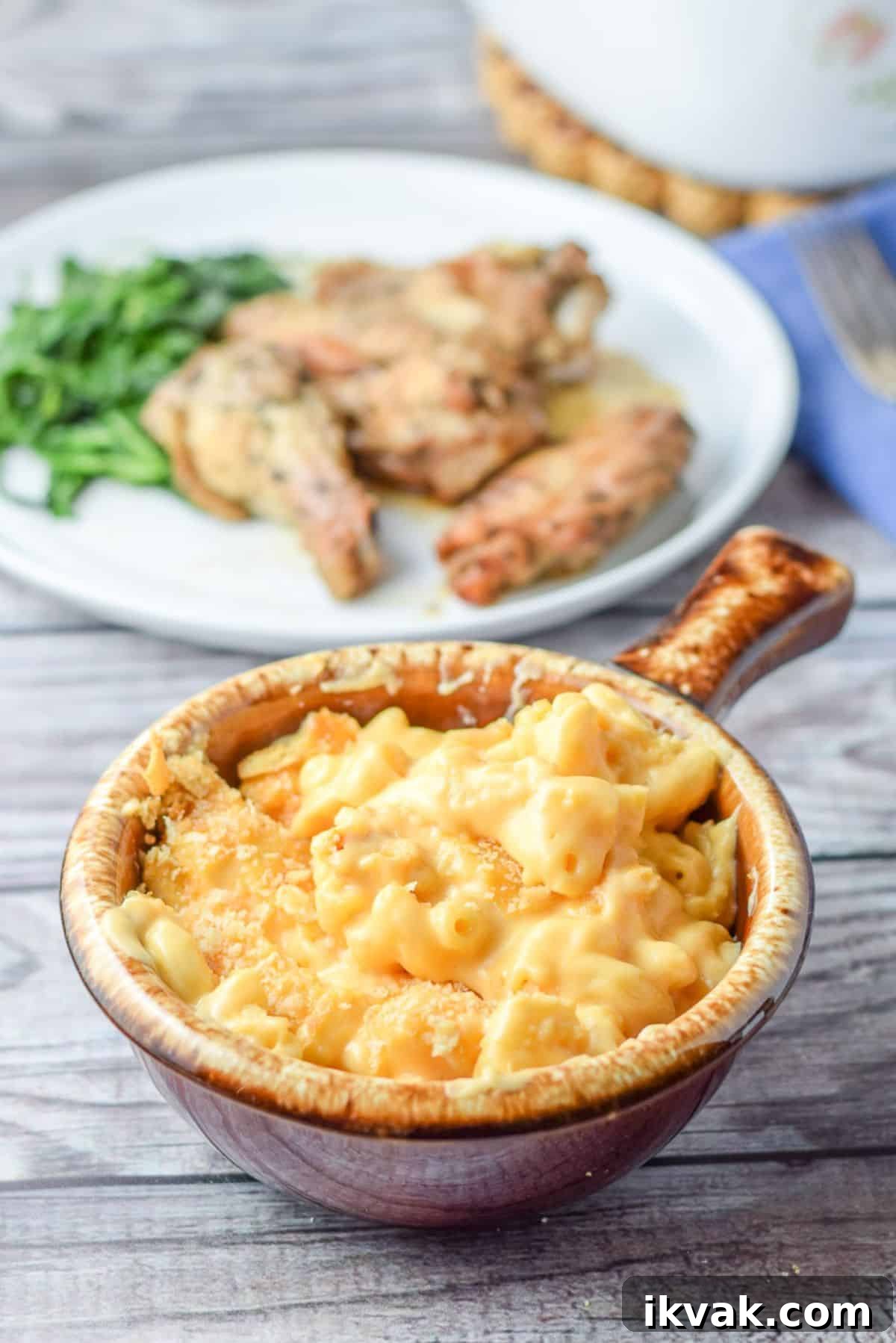 Ultimate Creamy Baked Mac and Cheese Recipe 2 A plate of food behind a brown crock of mac and cheese