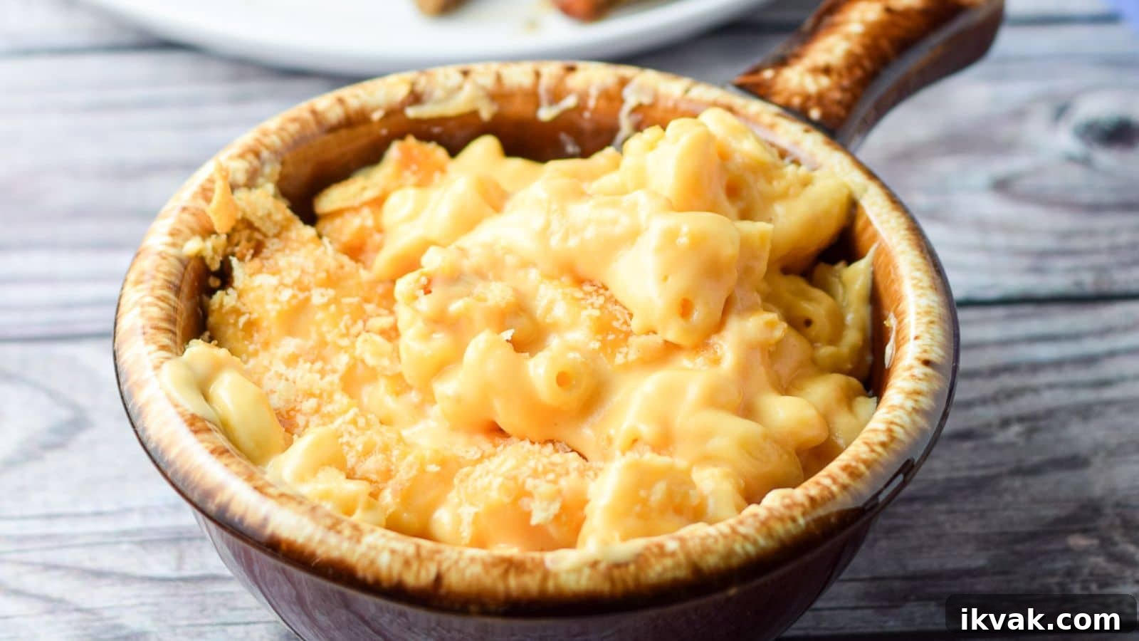 Ultimate Creamy Baked Mac and Cheese Recipe 3 A crock filled with mac and cheese with cracker crumbs on top