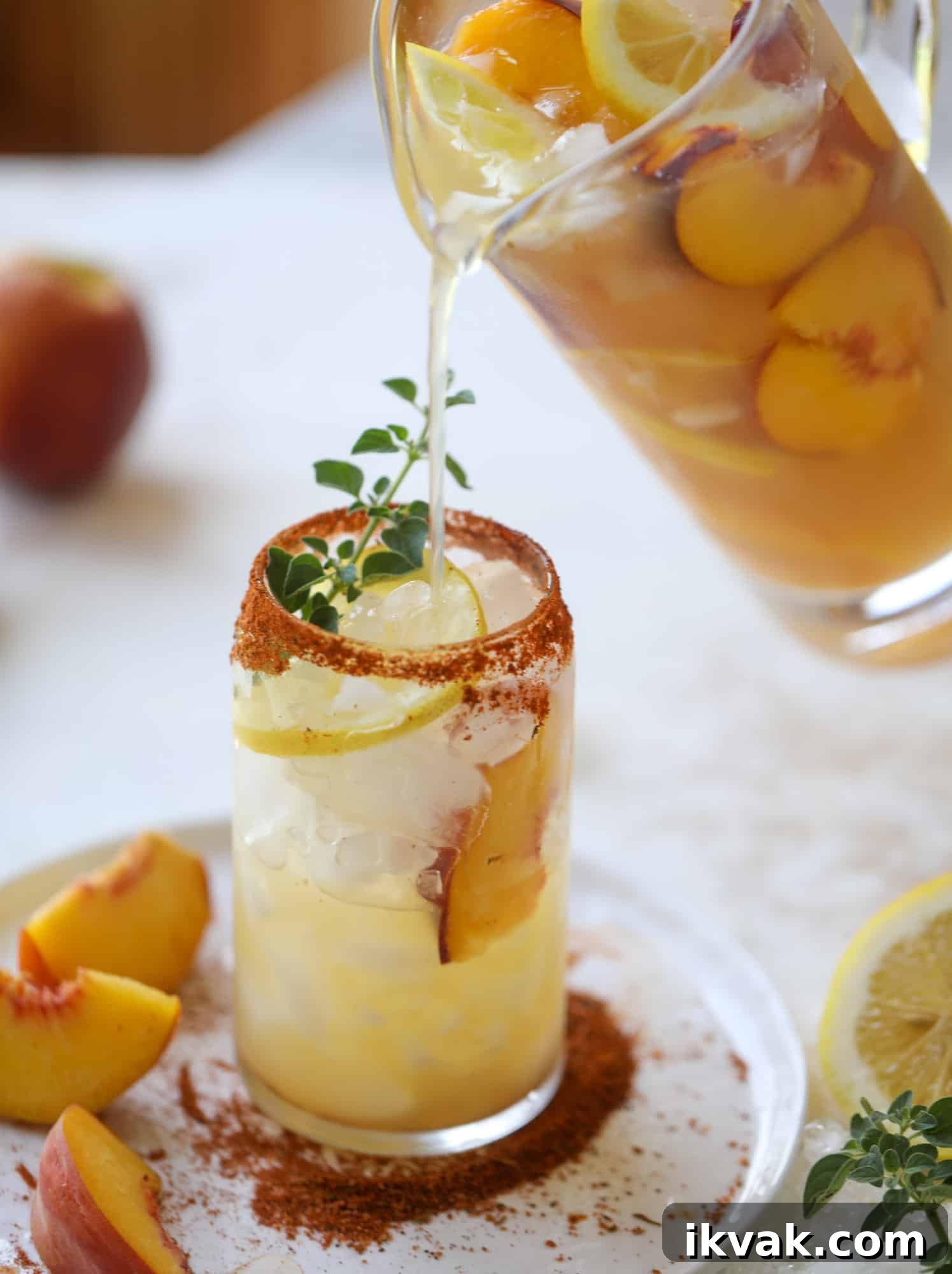 This peach lemonade is super refreshing and a bit spicy for a hot and sunny summer day. It's sweet and fresh and the rim is dipped in a cajun seasoning, bringing the best bite of heat to this perfect summer drink. So fresh! I howsweeteats.com #peach #lemonade #cajun #summer #mocktail #lemon #drink