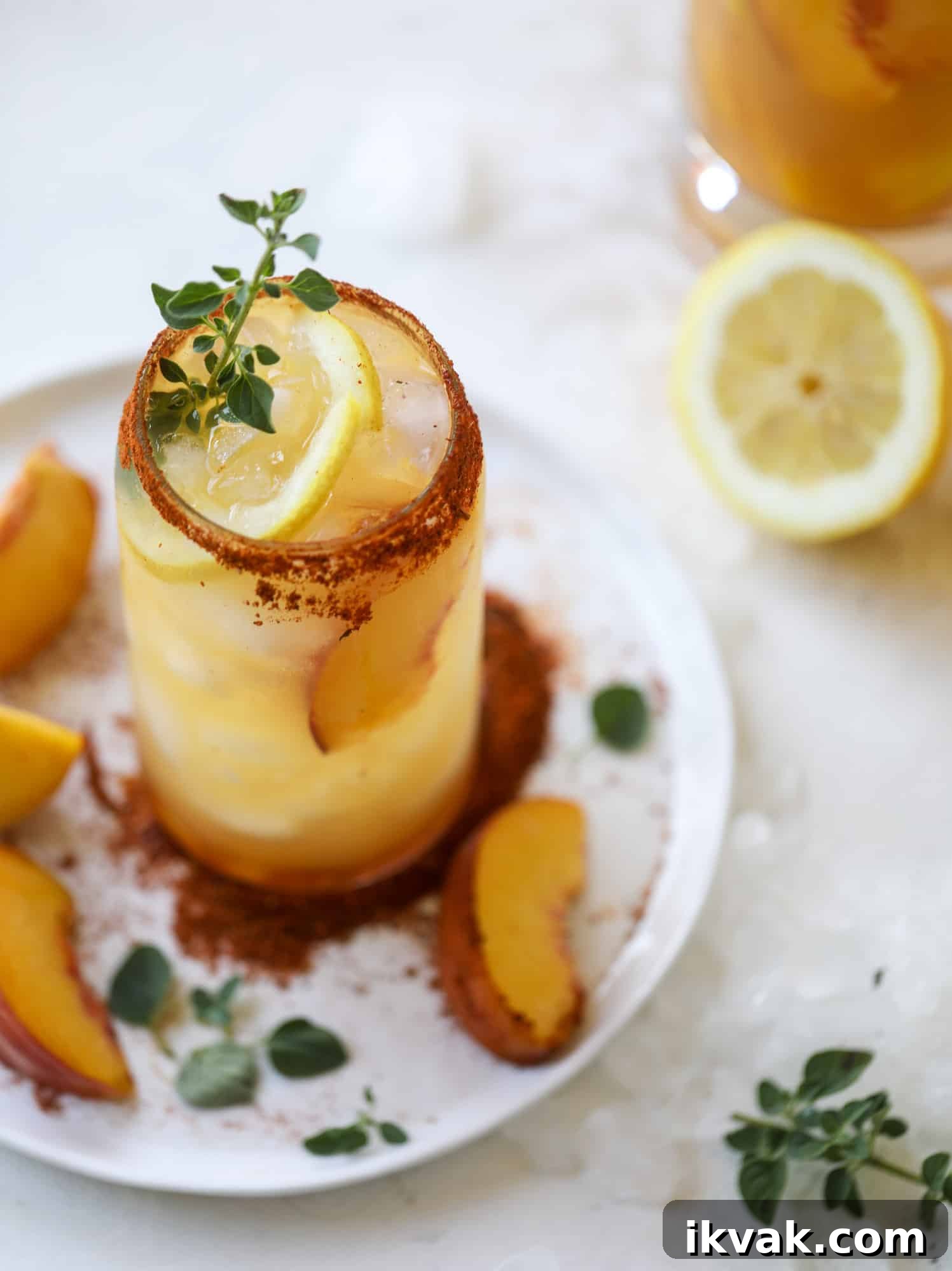 This peach lemonade is super refreshing and a bit spicy for a hot and sunny summer day. It's sweet and fresh and the rim is dipped in a cajun seasoning, bringing the best bite of heat to this perfect summer drink. So fresh! I howsweeteats.com #peach #lemonade #cajun #summer #mocktail #lemon #drink