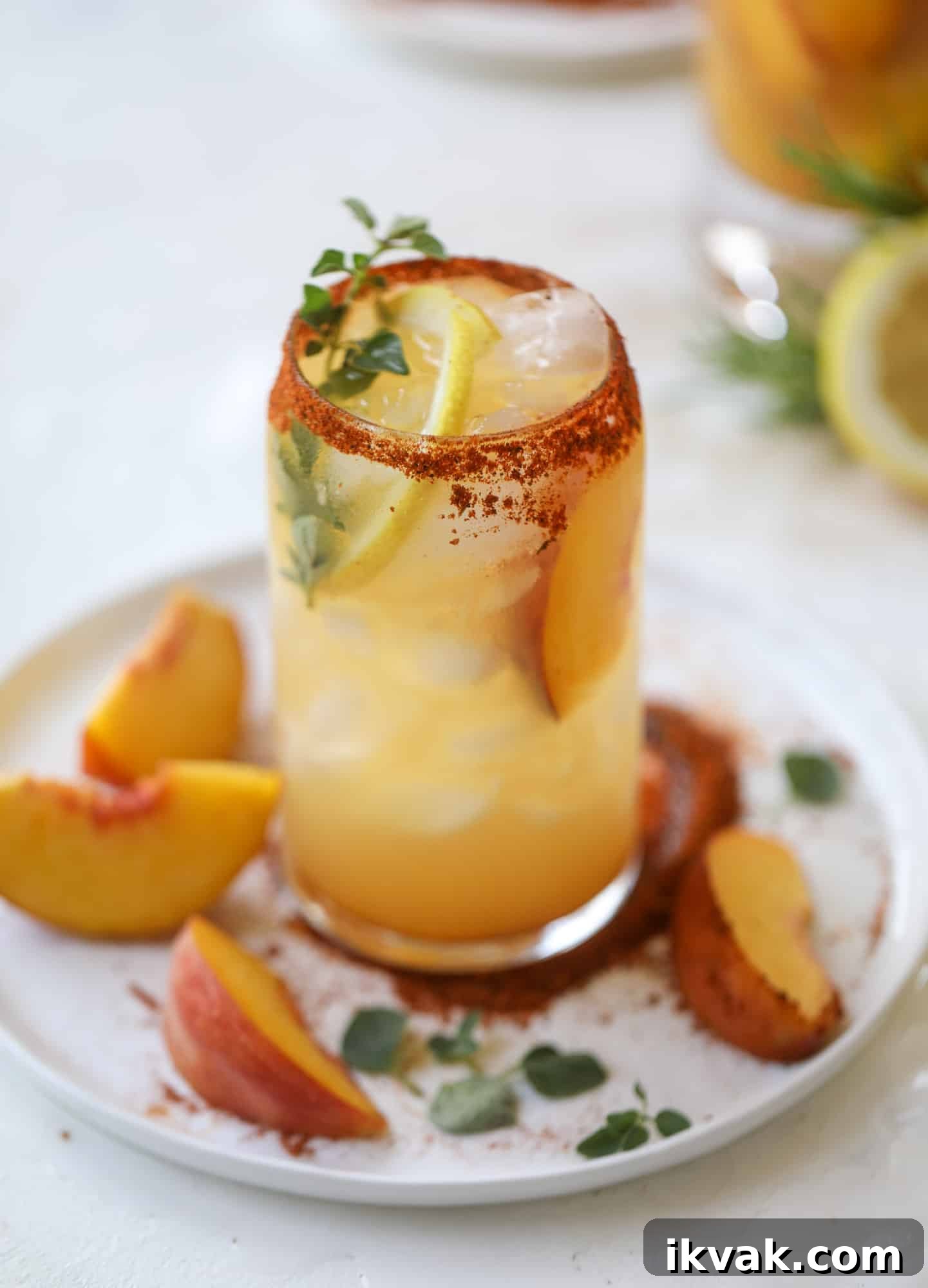 This peach lemonade is super refreshing and a bit spicy for a hot and sunny summer day. It's sweet and fresh and the rim is dipped in a cajun seasoning, bringing the best bite of heat to this perfect summer drink. So fresh! I howsweeteats.com #peach #lemonade #cajun #summer #mocktail #lemon #drink