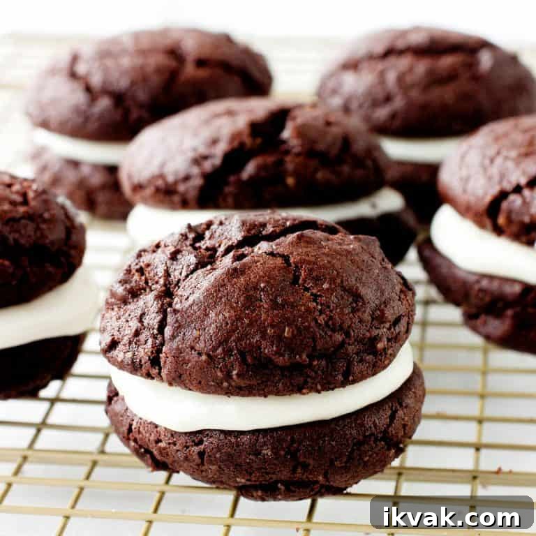 Several chocolate whoopie pies on a gold wire rack.
