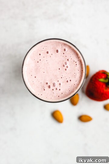 overhead view of strawberry almond smoothie in a glass