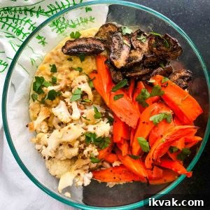 Bowl of lentils and faro, topped with roasted sliced mushrooms, carrot spears and cauliflower.