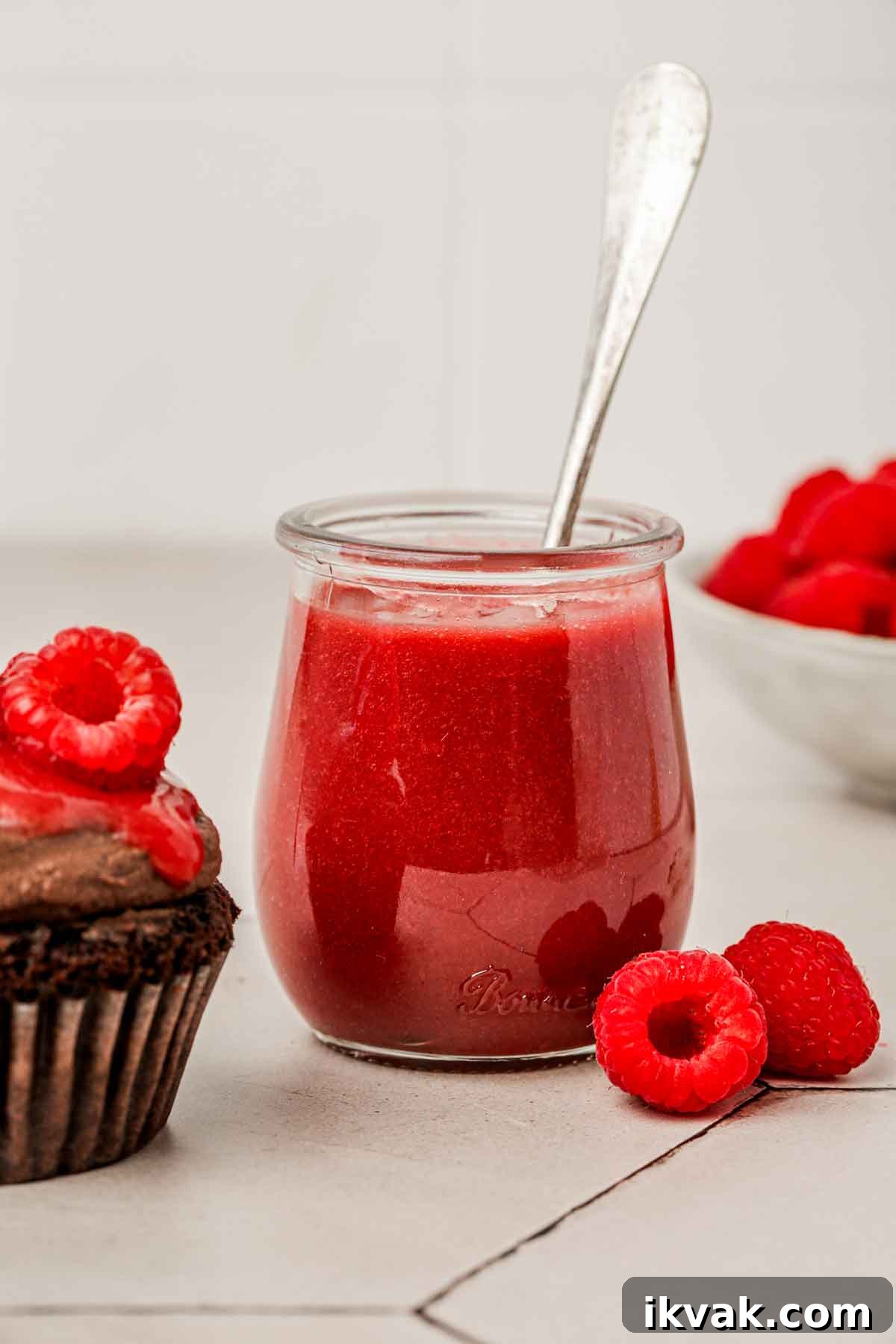 petit pot avec du coulis de framboise sur une table