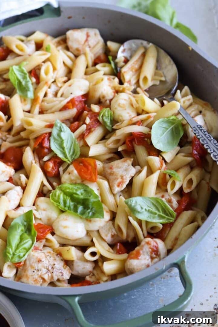Balsamic chicken pasta with cherry tomatoes, bocconcini and basil in a large skillet
