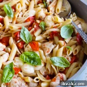 Balsamic chicken pasta with cherry tomatoes, bocconcini and basil in a large skillet