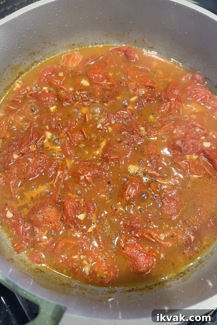 Cherry tomatoes and balsamic vinegar cooked into a sauce in a large saucepan