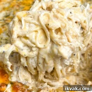 Creamy Chicken Tetrazzini Recipe for Home Cooks 2 Lifting a serving of chicken tetrazzini from the casserole dish