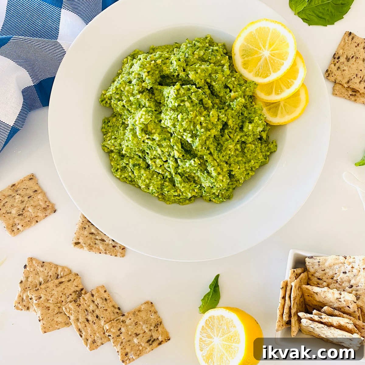 cashew basil pesto on a plate with lemon garnish and crackers