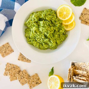 cashew basil pesto on a plate with lemon garnish and crackers