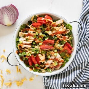 An overhead image of this salad with a half red onion, striped napkin and fried onions around it.