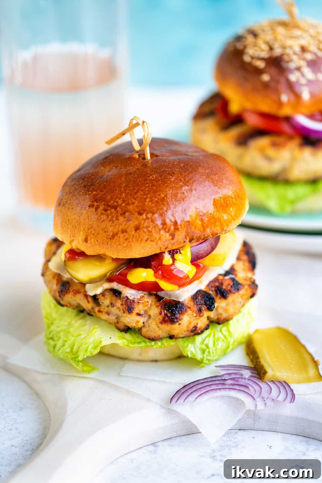 Grilled turkey burger in a brioche bun with ketchup, mustard, tomato, lettuce, onions, gherkins and cheese