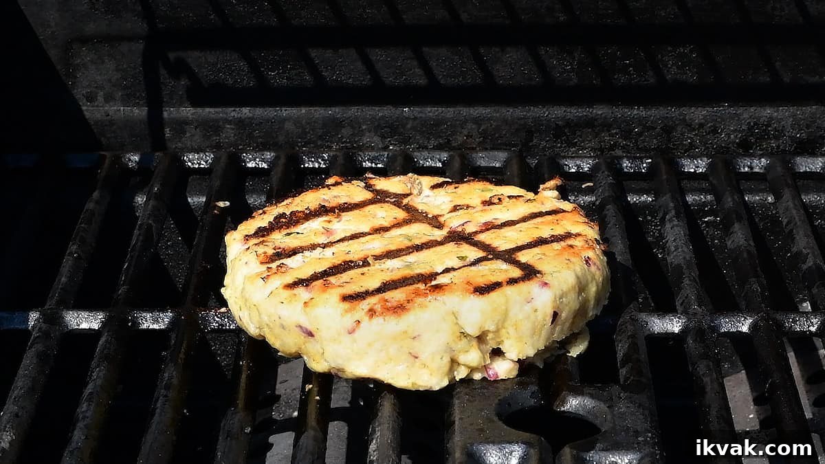 grilling a large turkey burger on the barbecue
