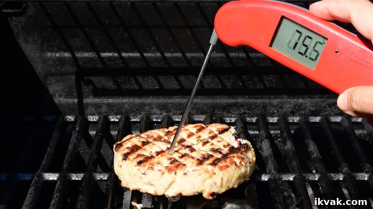 Checking the internal cooking temperature of a turkey burger using a digital thermometer