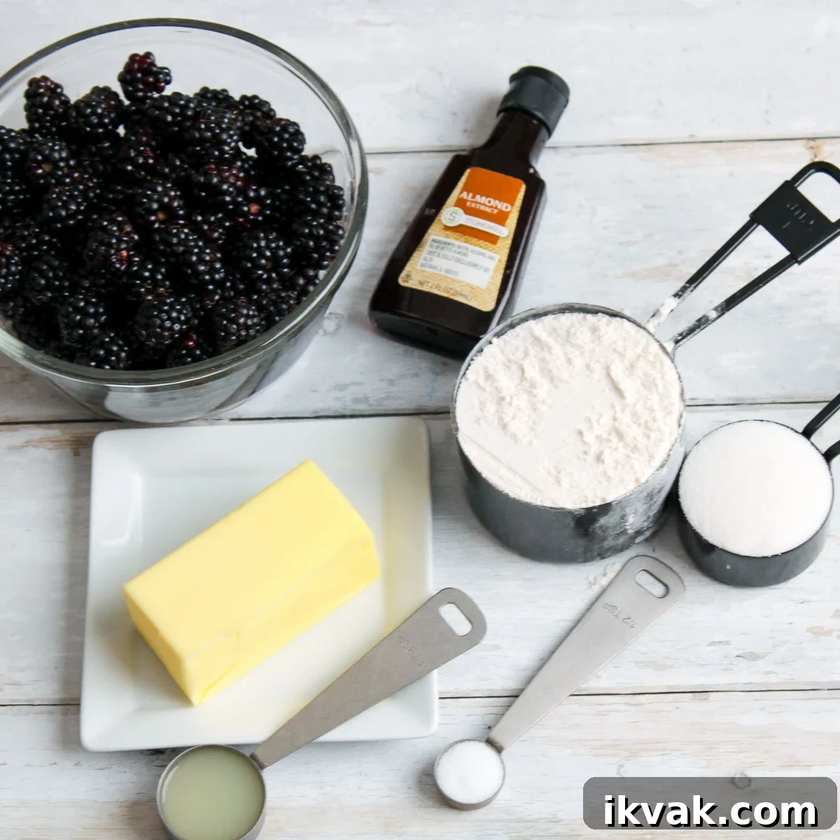 Ingredients for blackberry tart in individual dishes and measuring units.