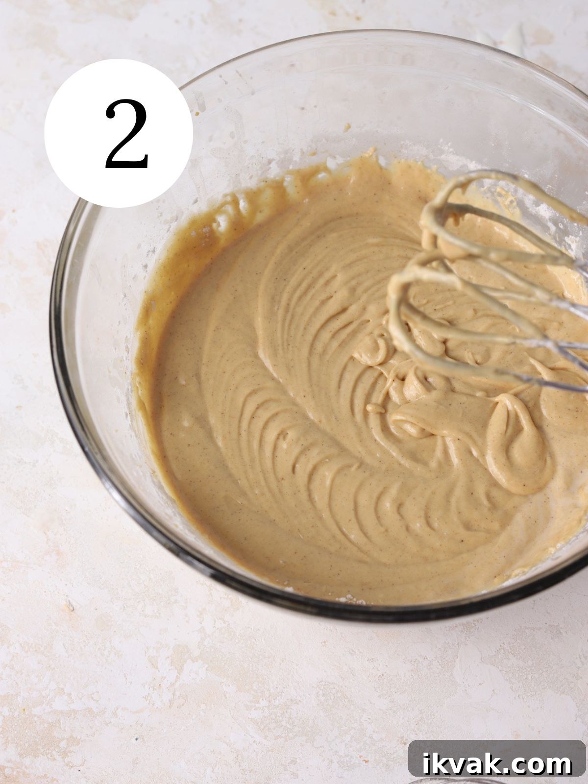 Irresistible Peanut Butter Donuts Recipe — Soft, Gooey, Homemade 5 A glass bowl with batter being mixed together with an electric mixer.