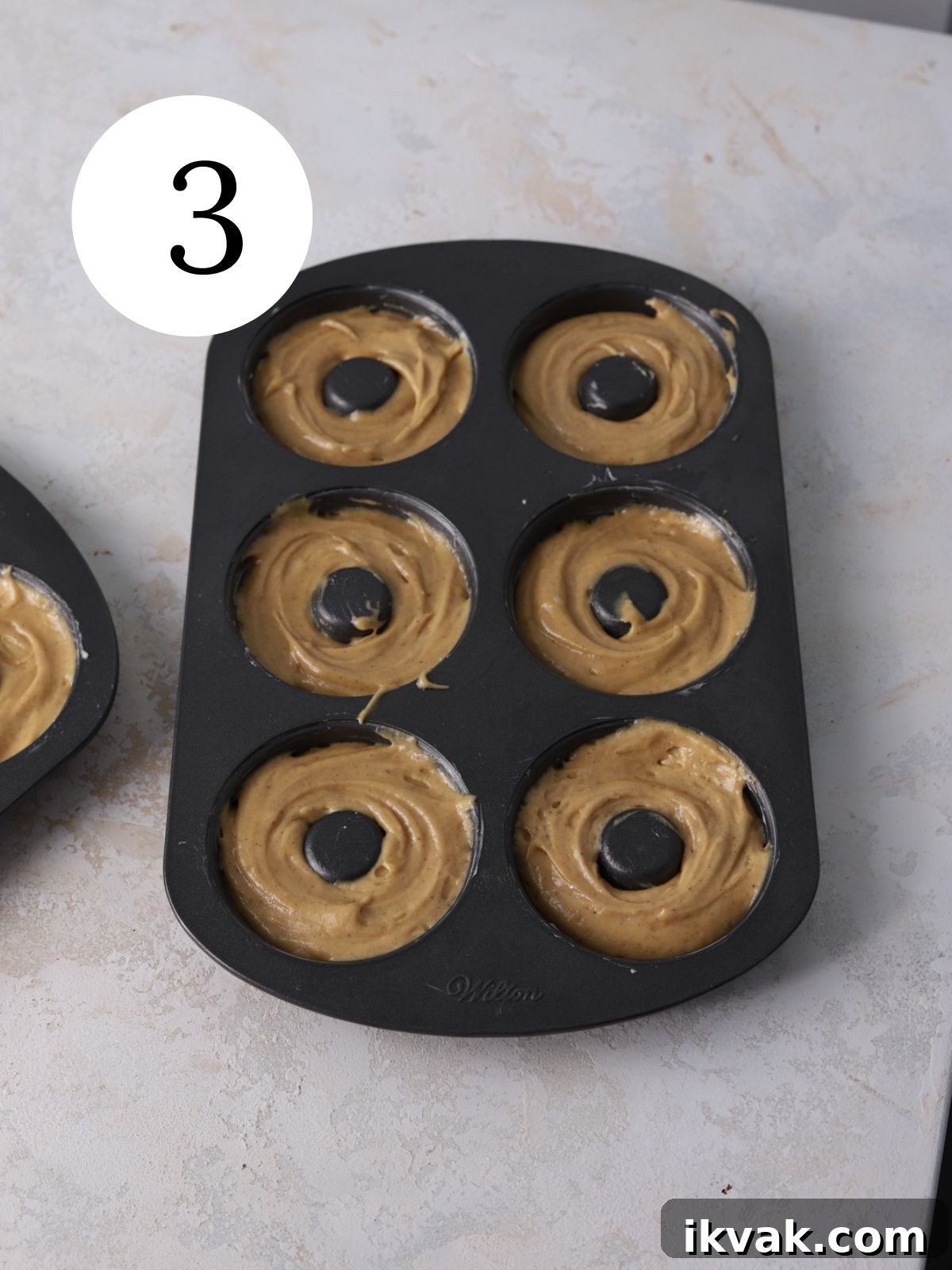 Irresistible Peanut Butter Donuts Recipe — Soft, Gooey, Homemade 6 A donut pan filled with donut batter.